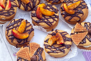 mini honey cakes with cream, decor of strawberry and chocolate topping close-up, horizontal