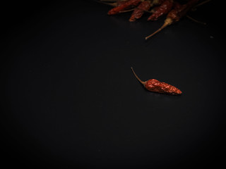 Close up red dried pepper on black background.blurry around,abstract art design.