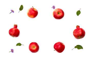 Red apples, garnets and violet flowers on a white background. Top view, flat lay