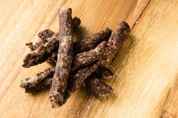Droewors (biltong) on a wooden board. This is a popular South African food snack. 