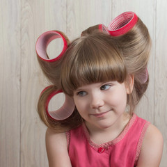Beautiful little girl with curlers on hair