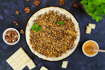 Honey cake with cottage cheese, oranges and nuts, decorated with white chocolate