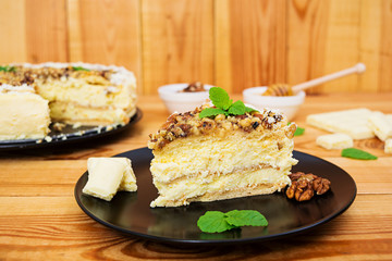 Honey cake with cottage cheese, oranges and nuts, decorated with white chocolate