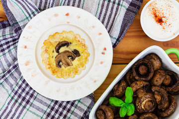 Tartlets with champignons on wooden background