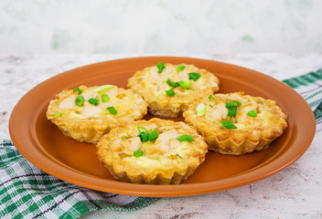 Tartlets with chicken and zucchini on white background