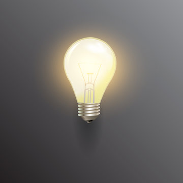 Realistic lit light bulb, isolated on black background. Vector illustration.