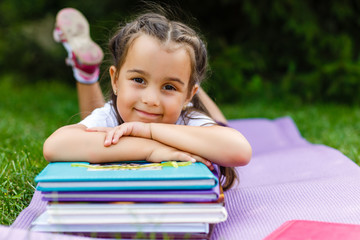 Adorable little schoolgirl in a city park on bright autumn day. Education for young kids. Back to...