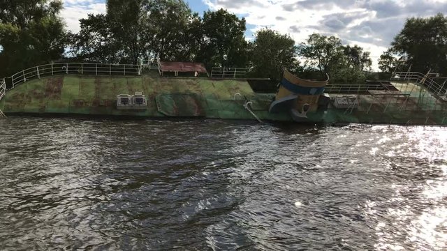 Kiev. Ukraine : - Sunken ship near the shore on the Dnieper River, lying on its side, half submerged in water.
