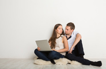 Young couple web surfing on laptop