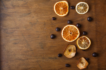 Slices of dried fruits on wooden board background