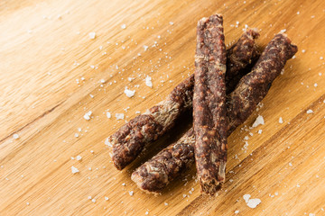 Droewors (biltong) on a wooden board. This is a popular South African food snack. 