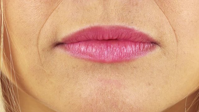 Closeup on a woman's full lips pressed into a thin line