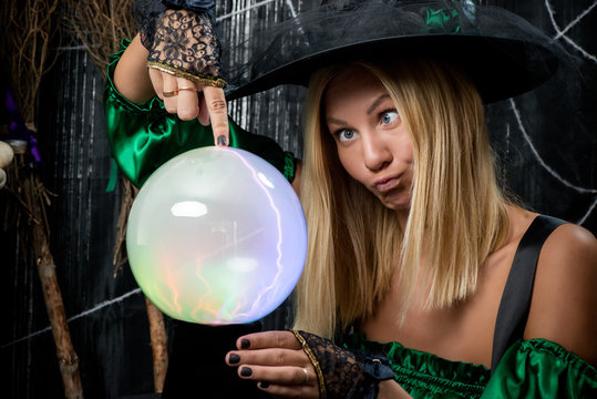 Beautiful young witch posing with magic ball