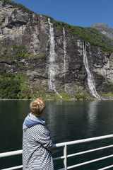 Fototapeta premium woman looking at the falls at the geiranger fjord norway