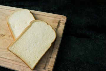 Sliced bread on wooden plate with old wood background