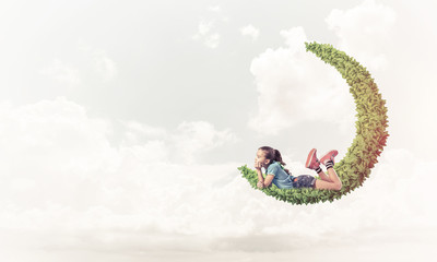 Concept of careless happy childhood with girl dreaming about som