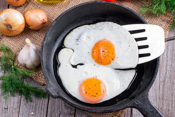 Fried eggs with spatula in frying pan