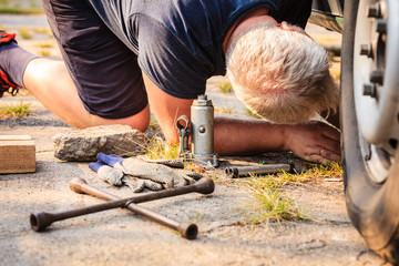 Casual man working under car fixing something