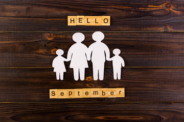 September Hello word with Paper silhouette of family. Wooden cubes with Hello September. Life insurance concept