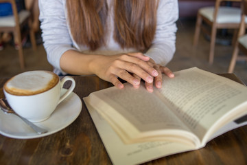 Reading book and enjoy hot cappuccino is young people's hobby