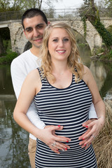 Happy man embracing wife while standing in park