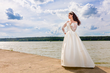 Fototapeta na wymiar Portrait of very beautiful bride and cloudy sky