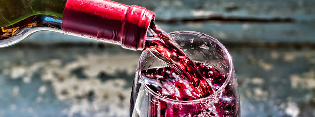 Verser du vin, verser du vin rouge. Vin dans un verre, mise au point sélective, flou de mouvement, Vin rouge dans un verre.