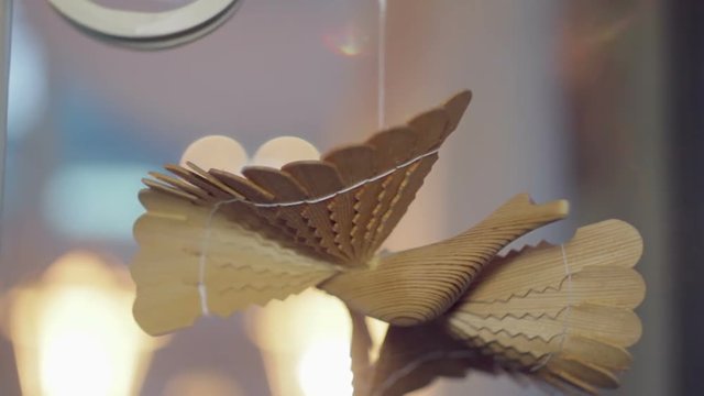 Russian bird of happiness, made of wood hangs by a thread under a ceiling in a house