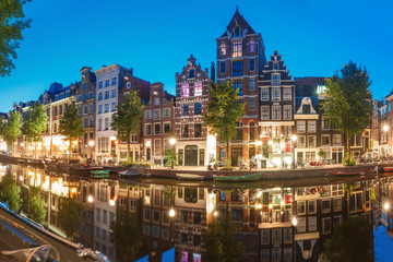 Fototapeta na wymiar Amsterdam canal Herengracht with typical dutch houses and their reflections during morning blue hour, Holland, Netherlands.