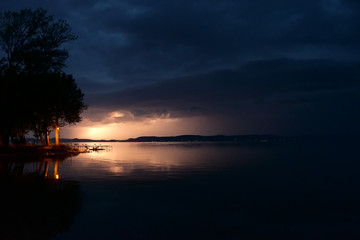 Fototapeta na wymiar lightning bolts and storm clouds over Balaton lake in summer, in night, at low light