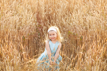 Little girl smiling on meadow at sunset