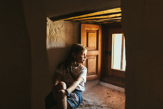 Little Sad Girl Looking Through Window