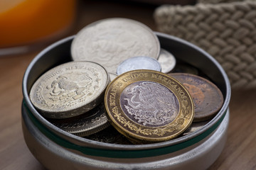 monedas mexicanas dentro de una lata
