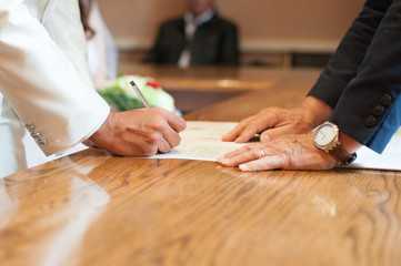 The groom signs his marriage at the town hall