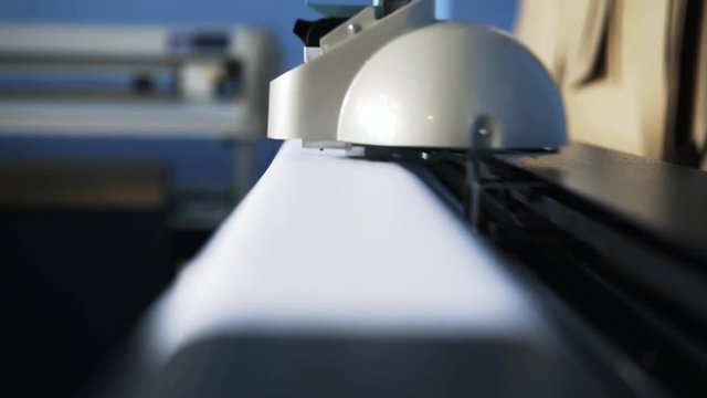 Close up of a plotter working in a print shop or in a company. Concept of complicated equipment. Locked down real time close up shot