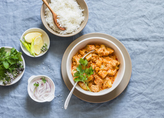 Cauliflower, potato curry and rice. Delicious vegetarian lunch, on a blue background, top view