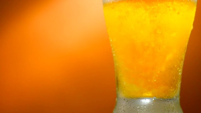 Cold beer pouring into a glass with water drops. Craft beer close up. Rotation 360 degrees. 4K UHD video footage. Ultra high definition 3840X2160