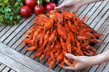 A plate of red crawfish in the hands