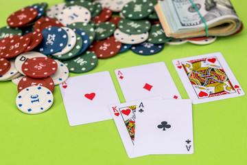 Poker chips and play card with dollar on green