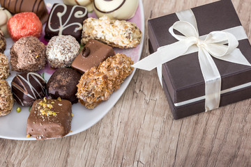 delicious sweets with cup of cappuccino and present box on desk.