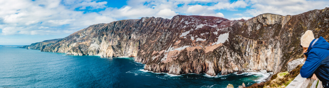 A woman looks out at Slieve League cliffs, Donegal, Ireland, the highest sea cliffs in Ireland.