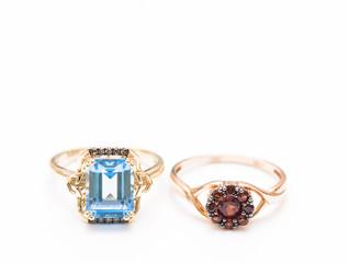 two gold rings with blue topaz and garnets
