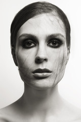 Young woman with black kind of spiderweb on her face