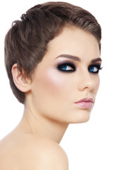 Fototapeta premium Young beautiful woman with pixie haircut and smokey eyes over white background, copy space