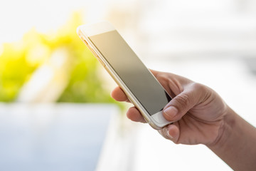 Young woman holding and using and touch screen on her smart phone.