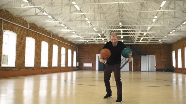 Young man spinning 2 balls on fingers. Basketball freestyle