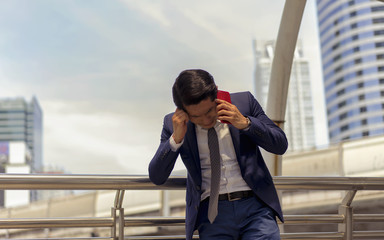 Businessman being depressed by working in office.Strain,Yong business man to think and not Work with stress Pretending to put his hand to the head