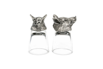 Two inverted glasses for vodka with a bottom in the shape of a head of a wild boar isolated on...