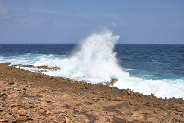 Big wave hits the sharp rocky coast of Aruba