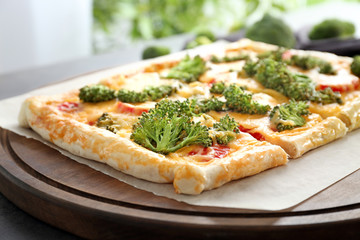 Traditional quiche with broccoli and cheese on board, close up